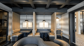 A modern room with a grey carpet and wooden walls.